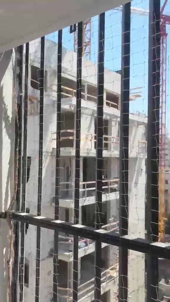 רשת נגד יונים על מעקה במגדל מגורים